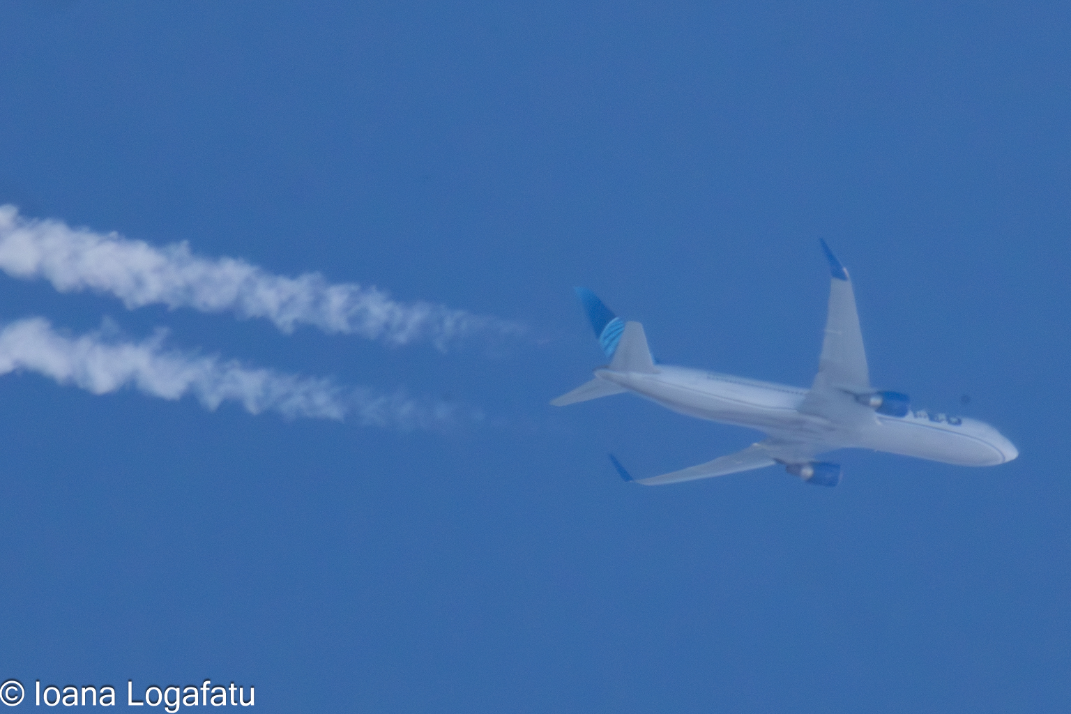 Airplane soaring high above the clear blue sky